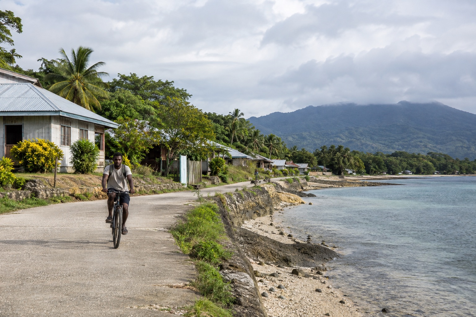 Cyclist on an illustrative Pacific coastal community road